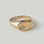 rotating video of a gold-plated signet ring with an oval face featuring a dazzling stone set in a starburst pattern
