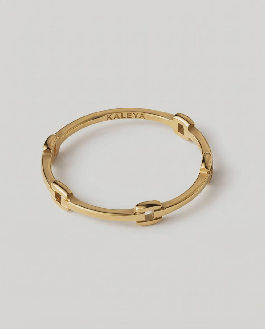 rotating video of a gold-colored ring with geometric cutouts, crafted from gold-plated metal, displayed against a white background.