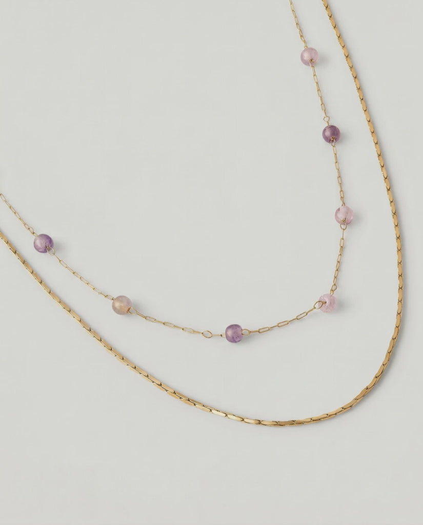 video of a two-strand gold-plated necklace with delicate rose quartz beads and a sleek snake chain.