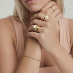 video of a model wearing a gold-plated stainless steel ring with a smooth, shiny finish and a substantial silhouette