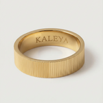 A gold plated band ring with a ribbed texture, displayed on a white background.