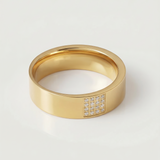 A gold-plated stainless steel ring with a polished finish and a section of the band adorned with pavé-set stones.